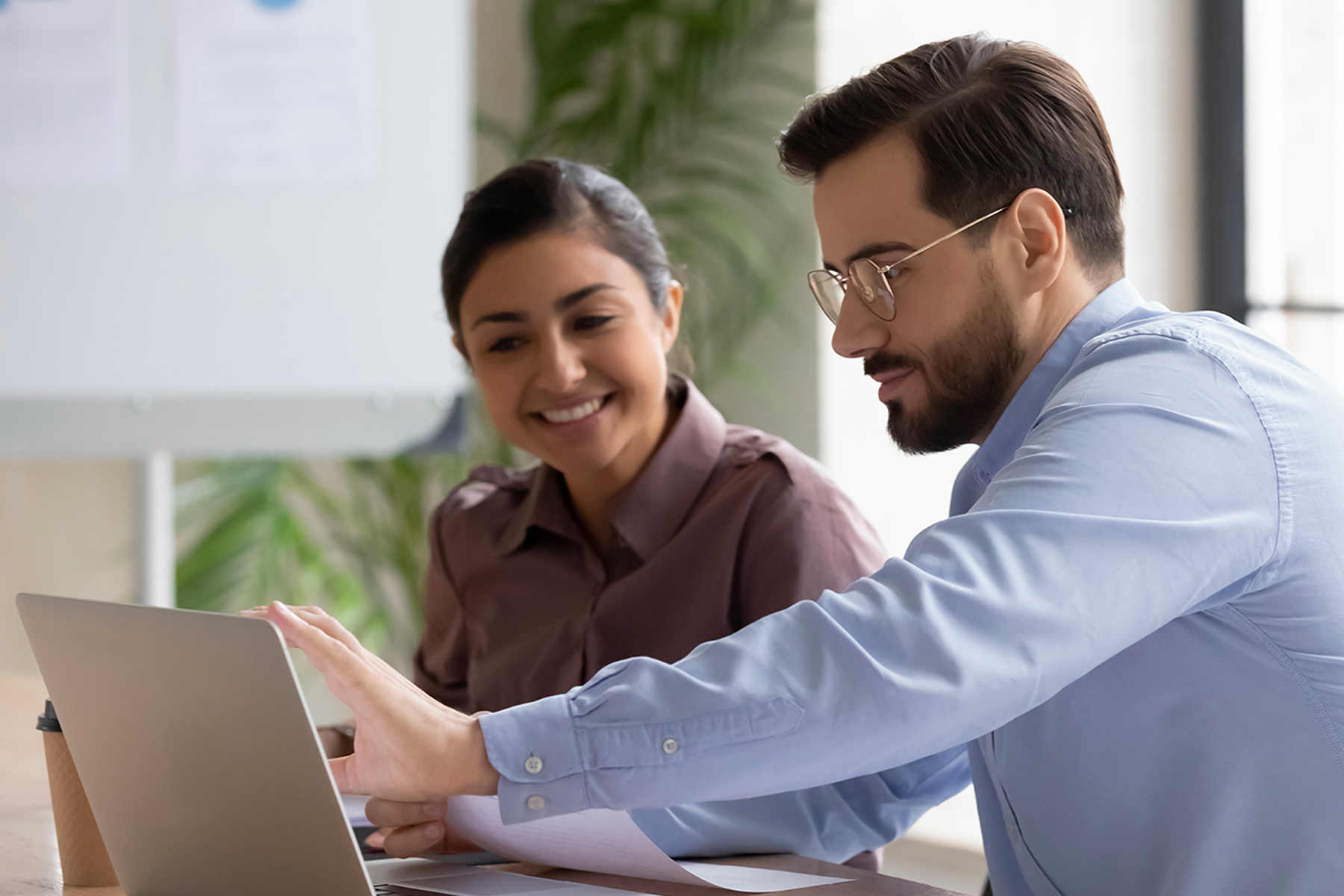 Two people working together on a laptop